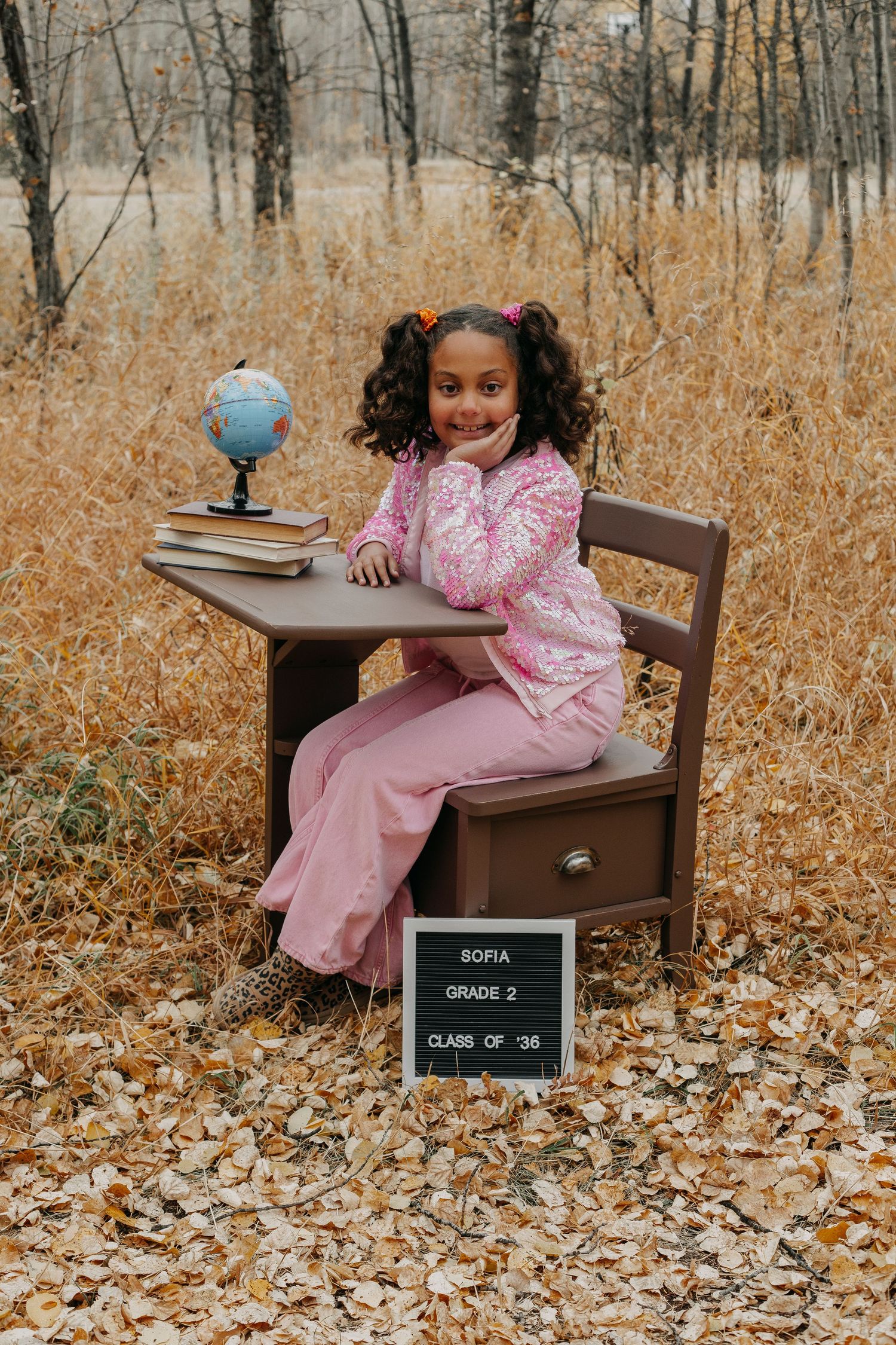 A series of five photos showing someone in a pink dress sitting on a wooden chair in an autumn forest setting.