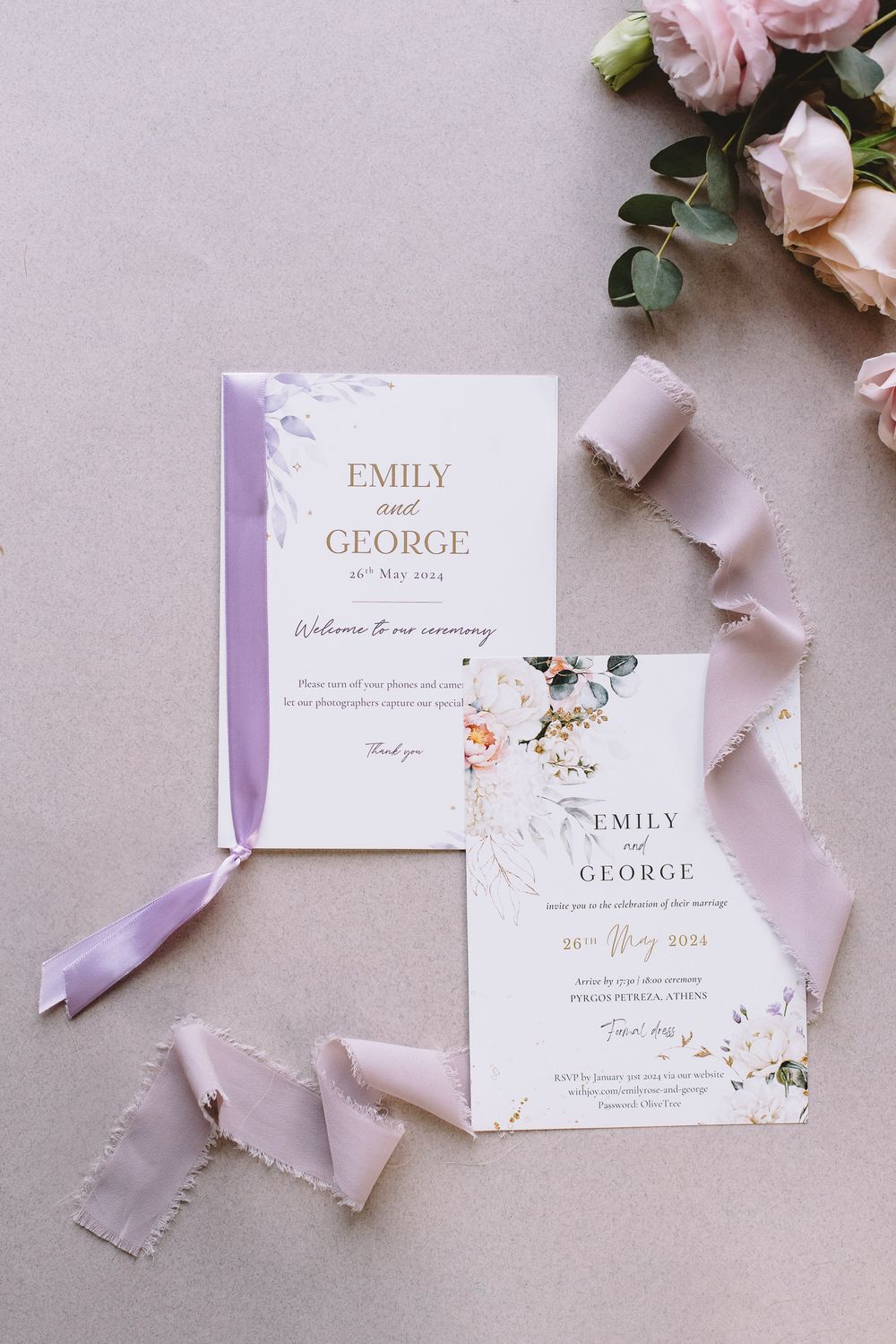 Elegant wedding invitation suite with pink roses and lilac accents on a neutral background.