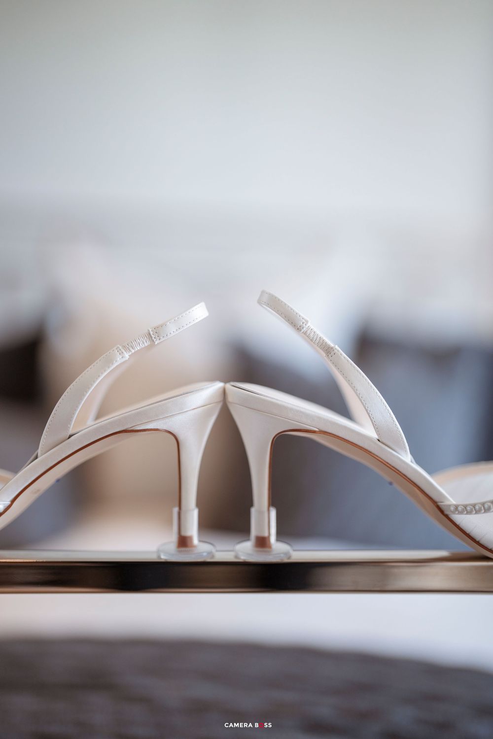 A series of minimalist photos showing elegant white bridal sandals from different angles on a wooden surface.