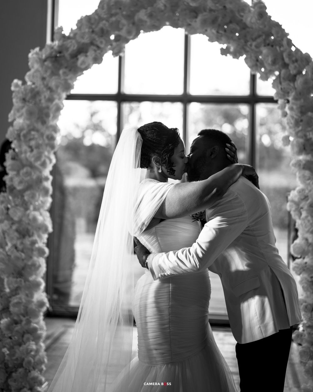 A black and white wedding photo sequence showing a couple sharing their first dance in an elegantly decorated ballroom.