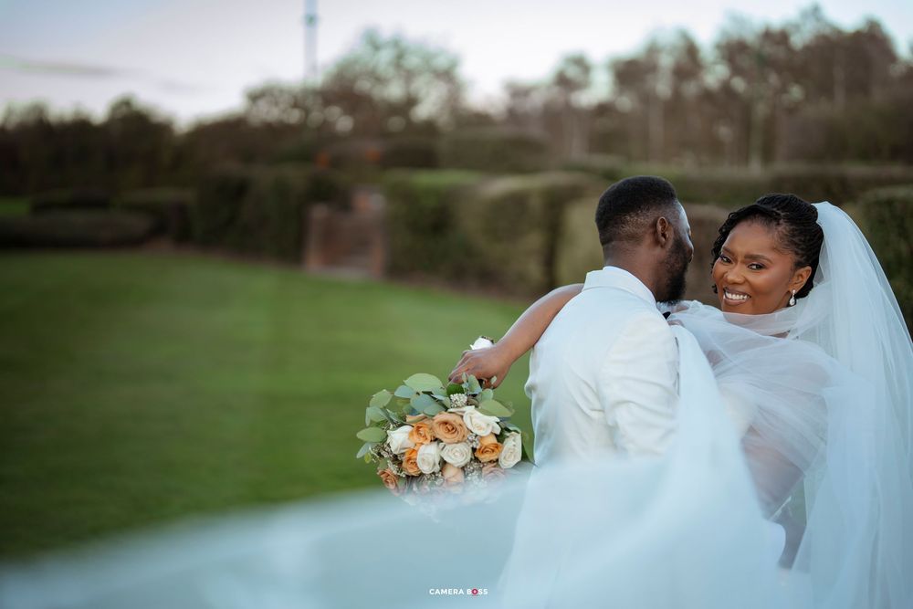 A wedding photoshoot featuring a bride in a flowing white gown with a bouquet in an outdoor garden setting.