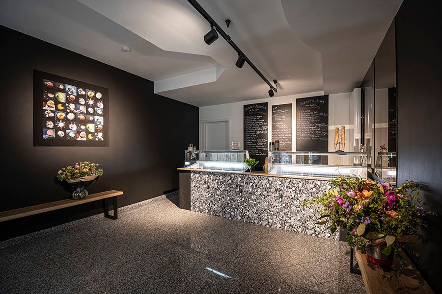 Modern interior space with track lighting and textured walls in dark tones.