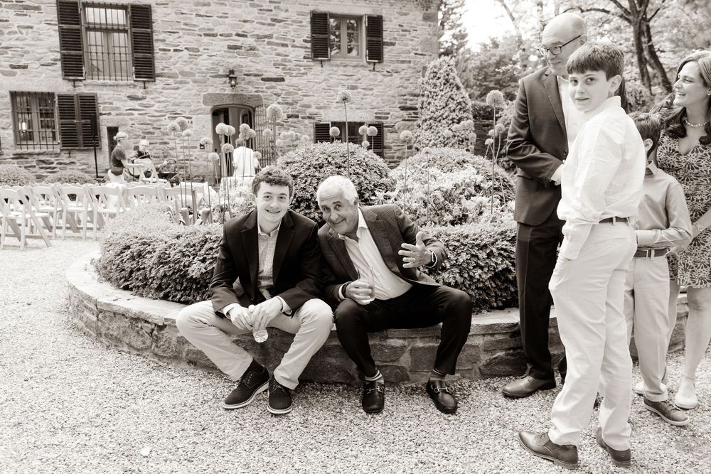 Group of people sitting casually on stone steps in a black and white photograph.