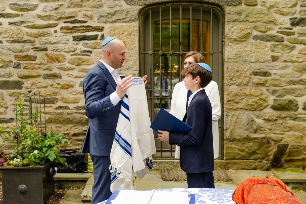 Stone building backdrop frames celebratory gathering near entrance.