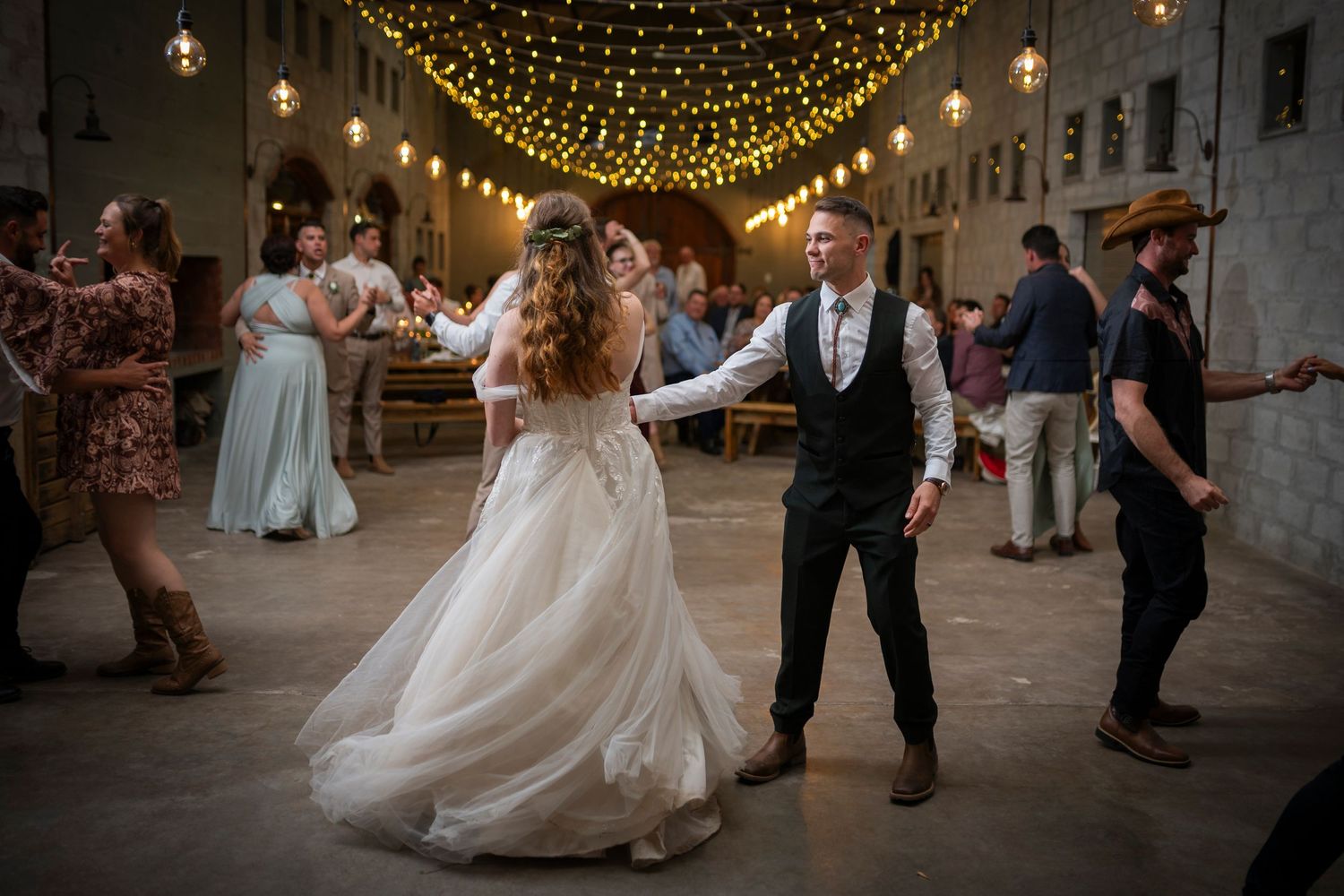 A string of warm twinkle lights creates a magical canopy over an evening dance floor.