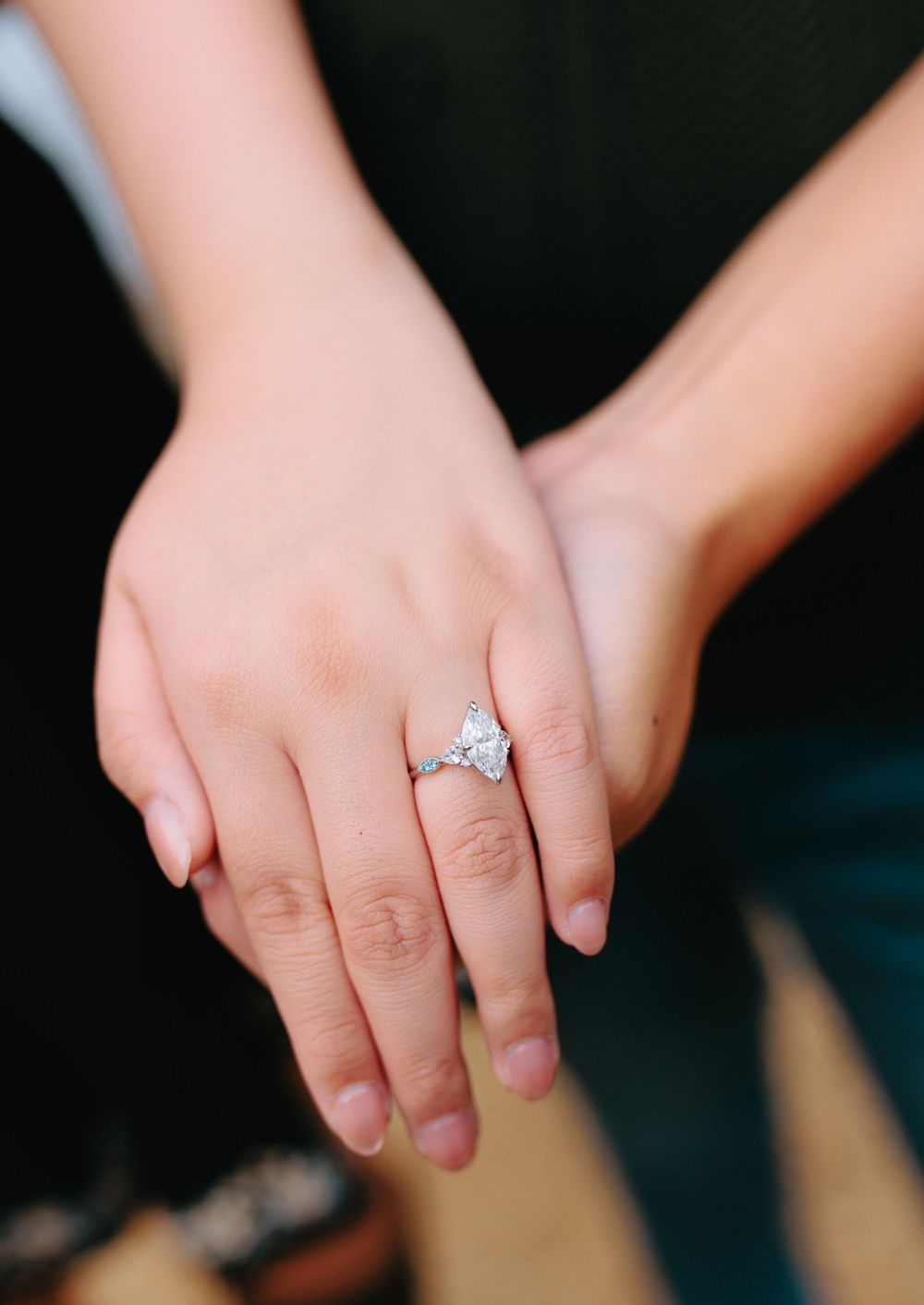 A close-up sequence of hands showing off a sparkling diamond engagement ring from different angles.