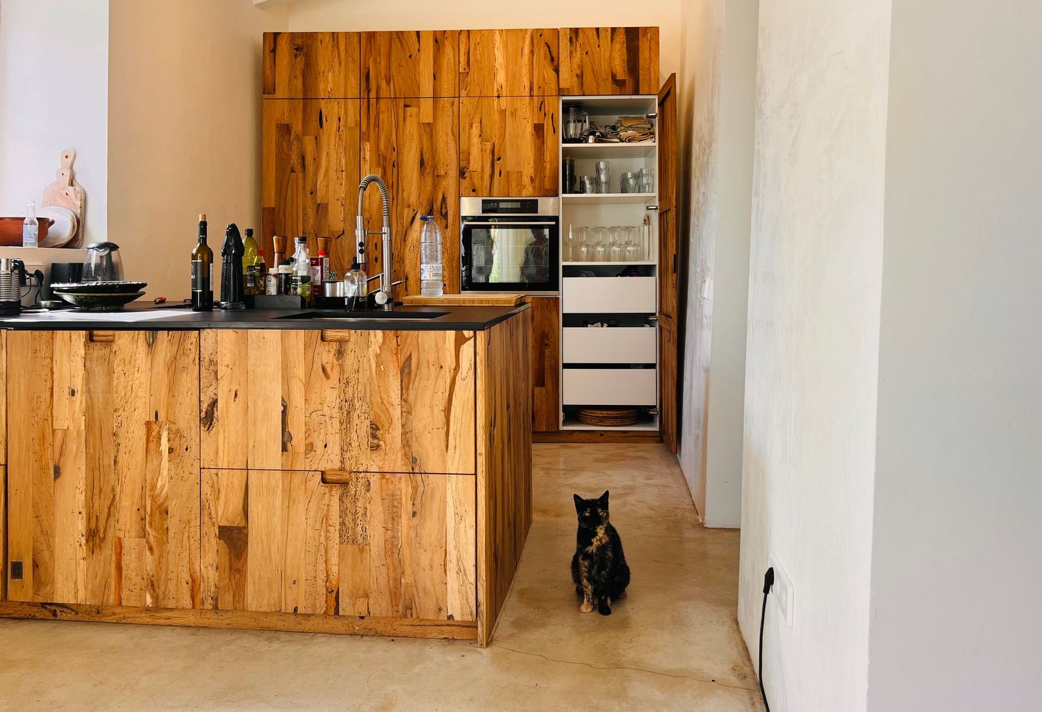 Modern kitchen interior with wooden cabinets and white walls featuring minimalist design elements and clean lines.
