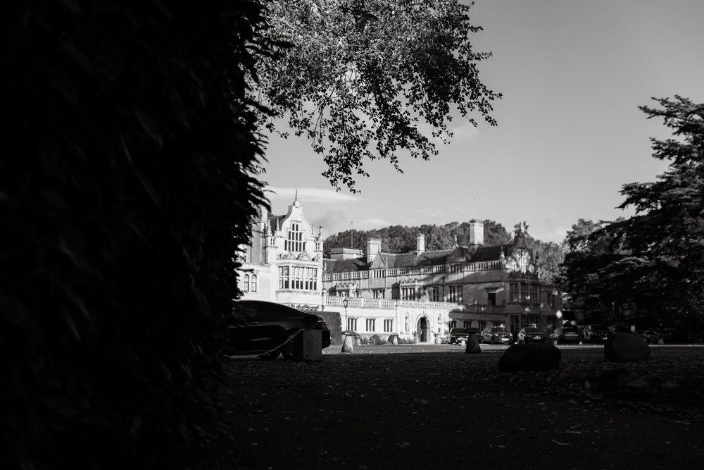 Panoramic black and white view of a grand historic mansion exterior with architectural details.