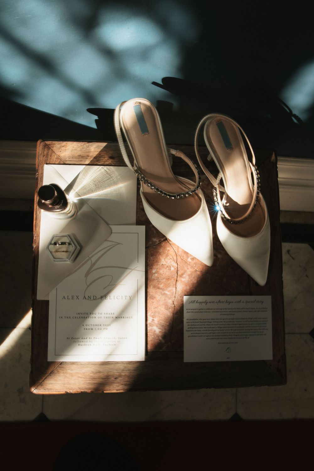 Wedding invitations and stationery arranged in dramatic lighting on a dark surface.