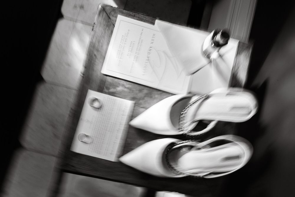 Artistic black and white detail shot of wedding accessories and paper elements.