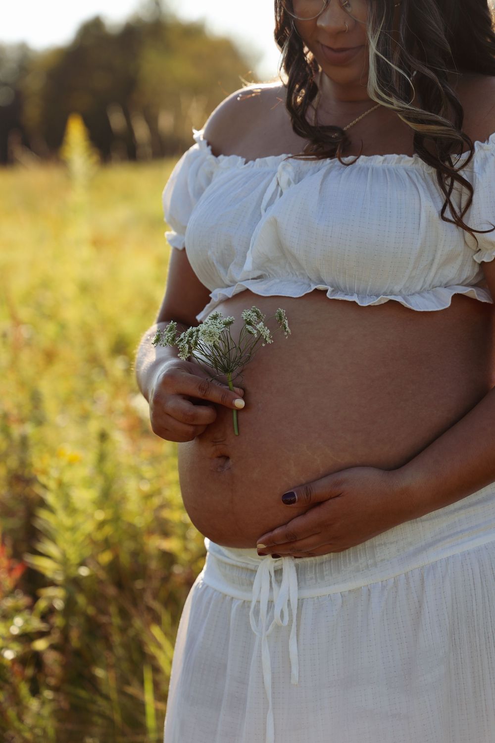 Connecticut maternity photoshoot. pregnant woman in white flowy outfit in field