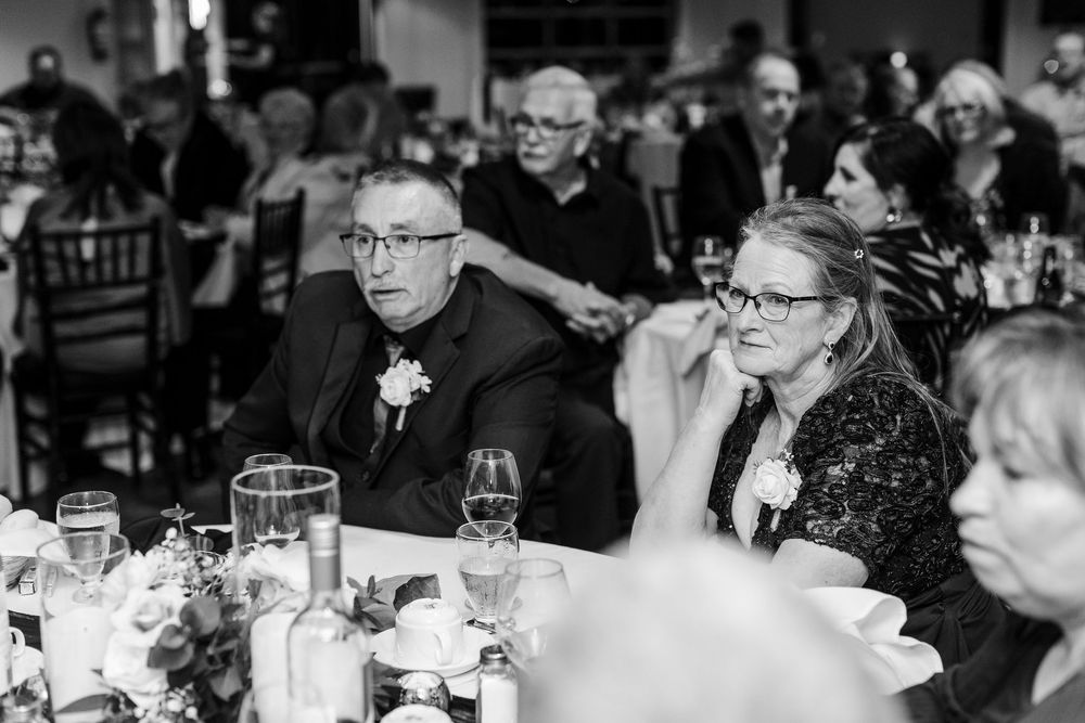 A large group of people seated at tables during a formal dinner event in a banquet hall.