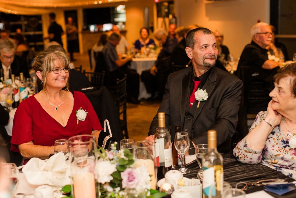 People seated at an elegant dinner table with wine glasses and table settings in a dimly lit restaurant atmosphere.