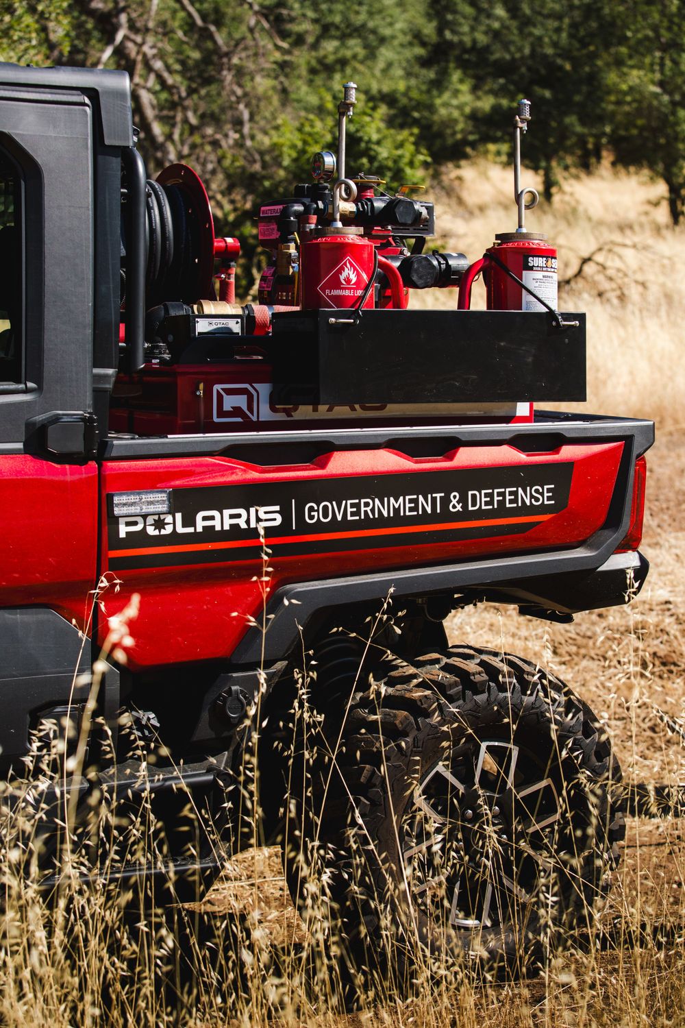 Red Polaris Government & Defense vehicle equipped with specialized equipment in an outdoor setting.
