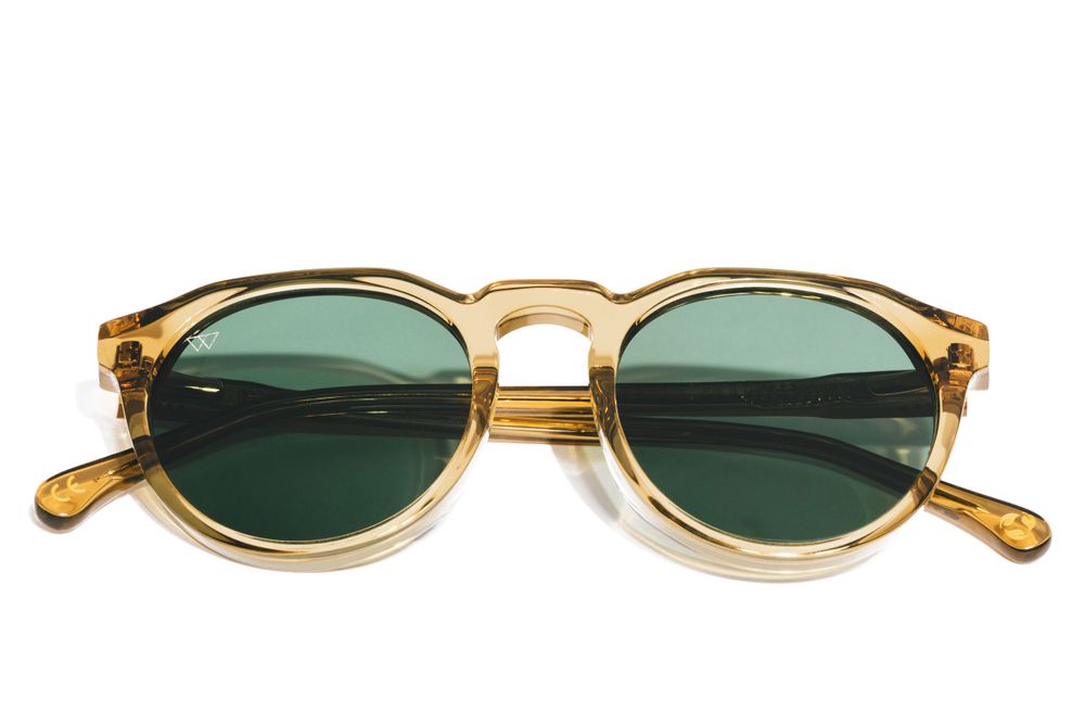 Vintage-style round amber sunglasses with green lenses photographed from above.