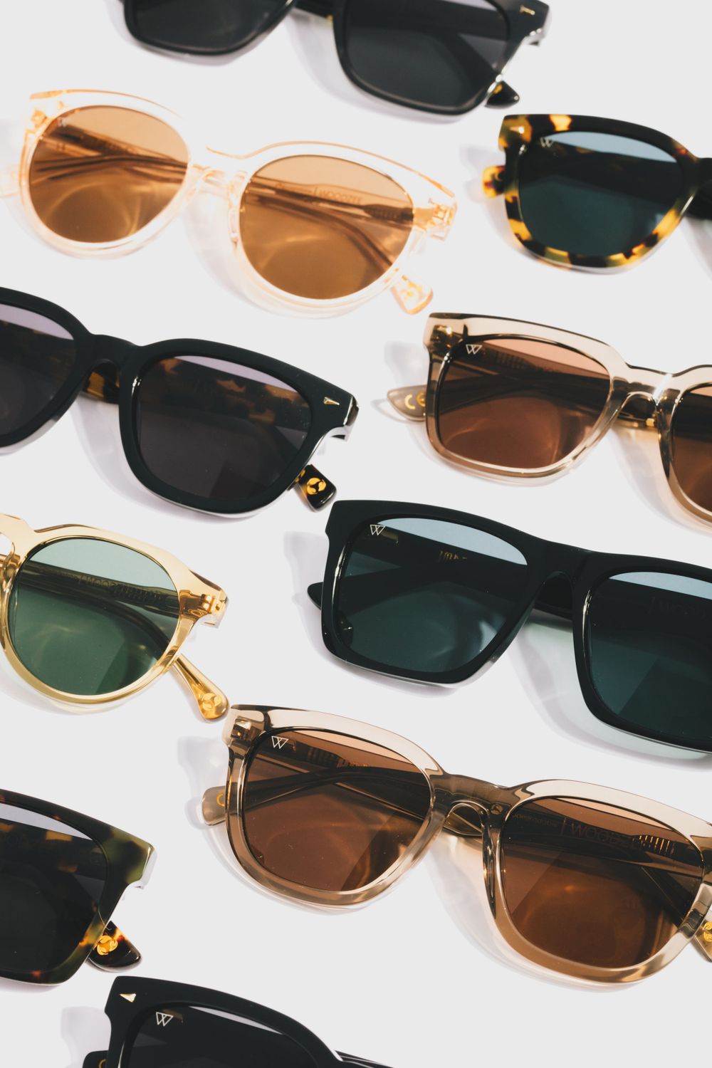 Collection of stylish sunglasses in various colors and frames displayed on white background.