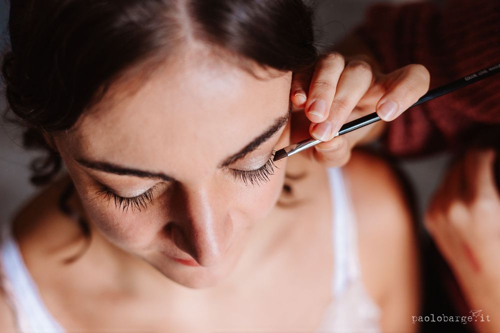 Close-up shot of make-up application focusing on eyelash details during bridal preparation.