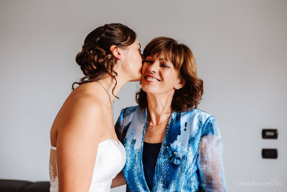 A touching candid moment of shared laughter and joy during wedding preparations.