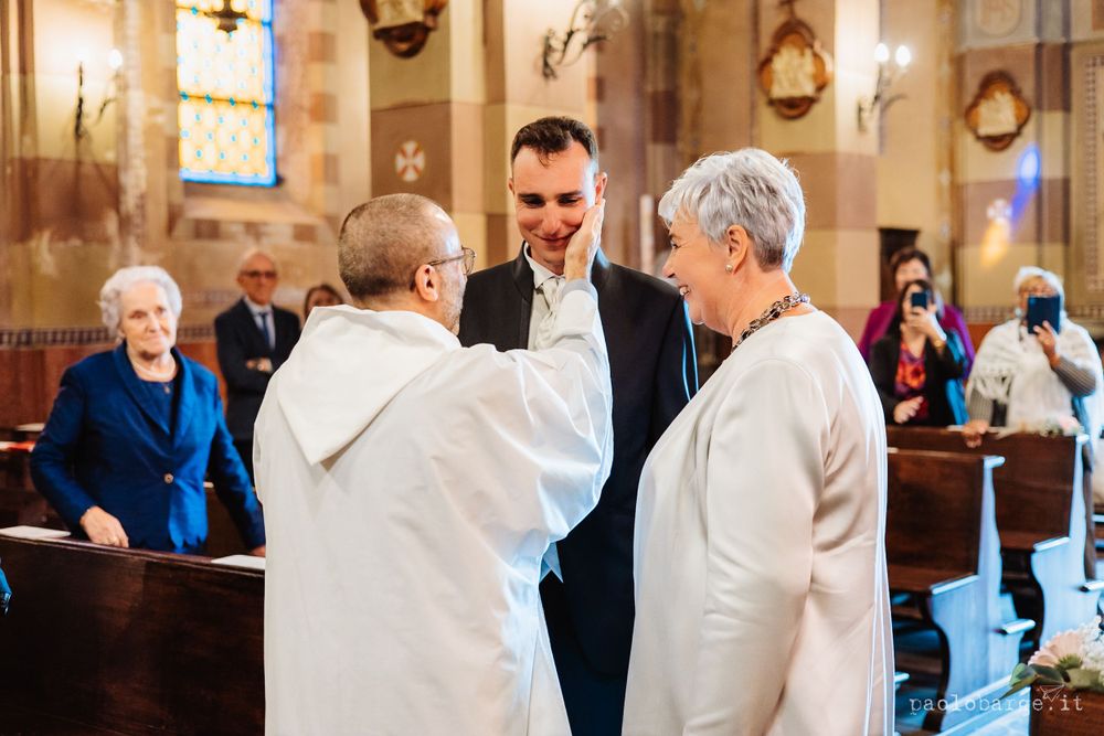 A ceremony takes place inside a traditional church with stained glass windows and ornate decorations.