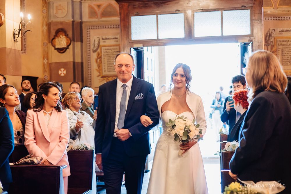 Wedding processional in ornate church interior with decorative walls and windows.