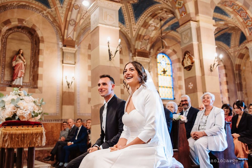 Wedding ceremony in progress inside historic church with beautiful arched architecture.
