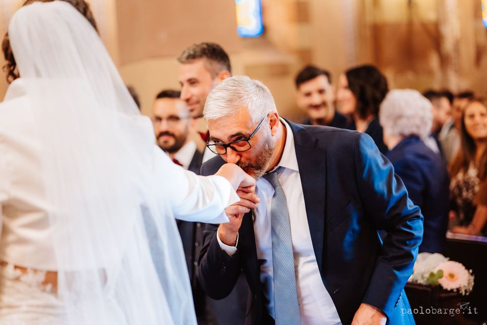 Guest in formal attire shows respect during traditional wedding ceremony moment.
