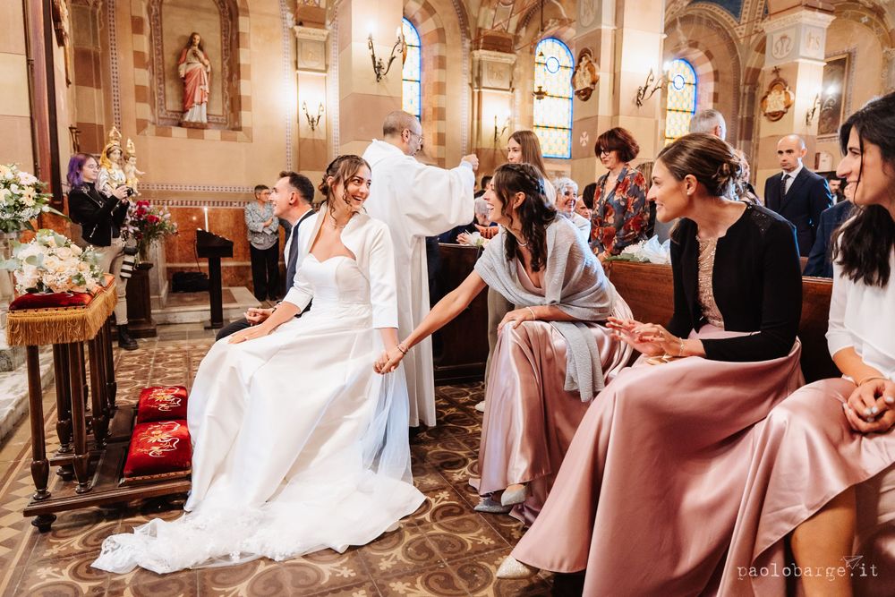 Wedding celebration inside an ornate church with guests seated in traditional pews.