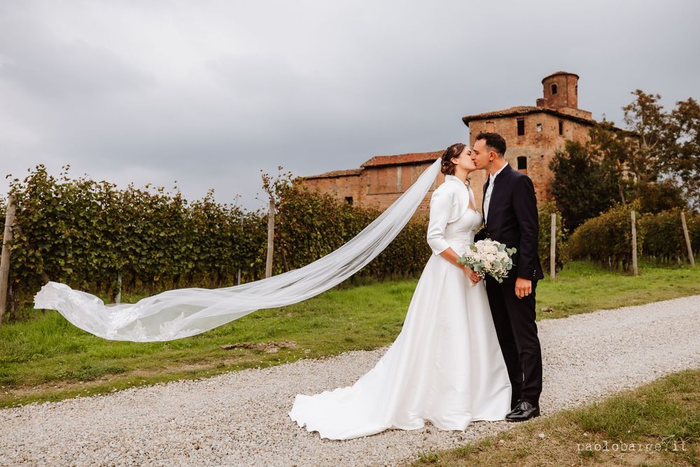 A flowing white wedding veil catches the breeze against Italian countryside backdrop.