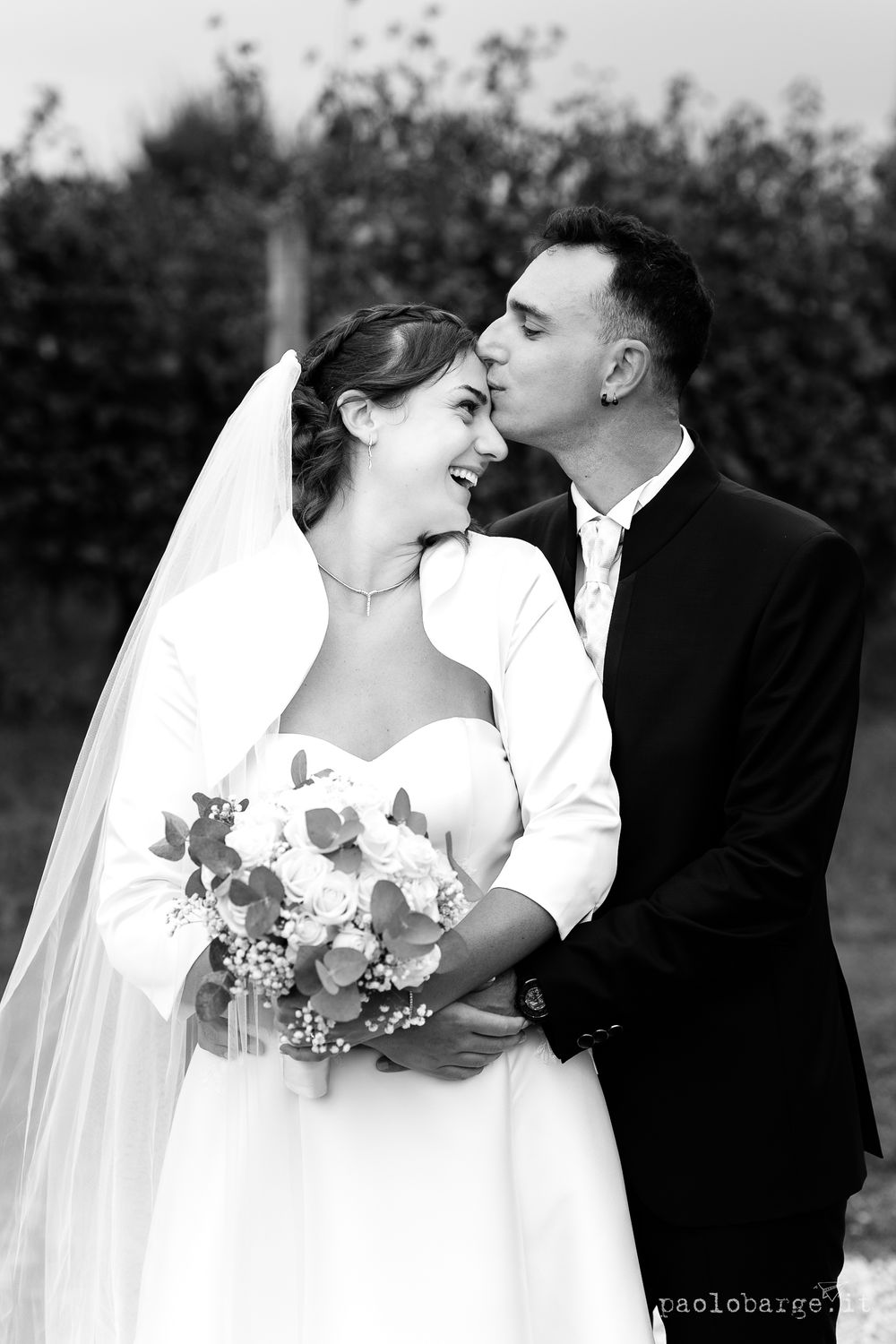 Black and white romantic wedding portrait with bouquet of white flowers.