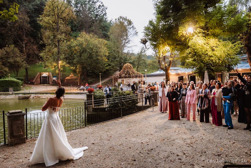 Wedding celebration by a pond with guests gathered for an outdoor ceremony.