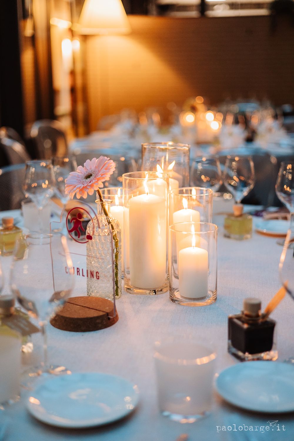 Elegant wedding table setting with glowing candles and delicate glassware.