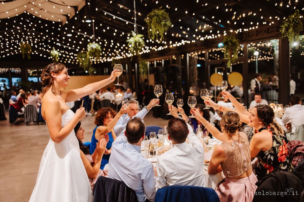 Wedding celebration with guests dancing under strings of fairy lights at an evening reception.