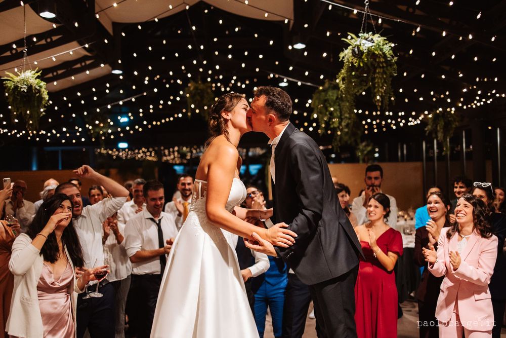 Couple sharing a romantic moment during their first dance under twinkling reception lights.