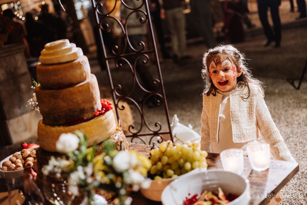 A rustic wedding dessert display with tiered naked cake and table decorations.