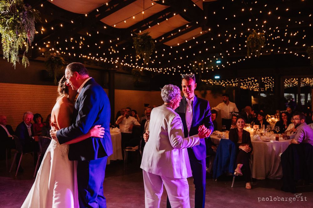 Wedding reception dance floor with string lights and purple lighting creating romantic atmosphere.