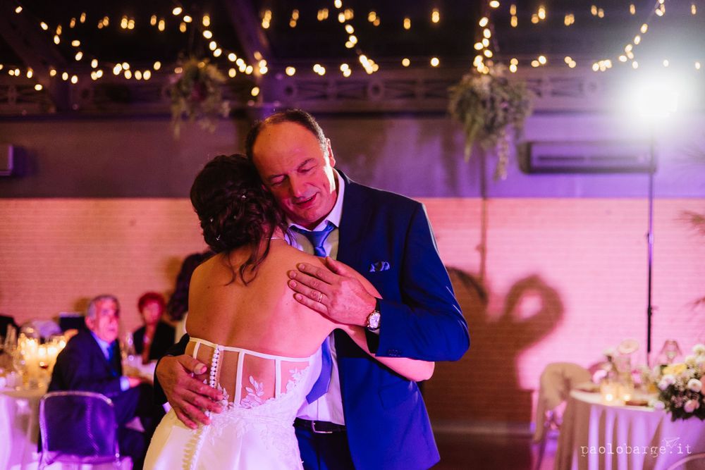 Romantic dance moment under warm lighting at wedding reception.