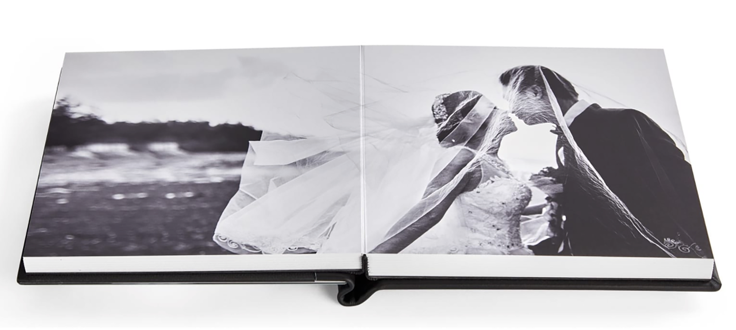 Wedding photo album opened to display a black and white romantic couple photograph.