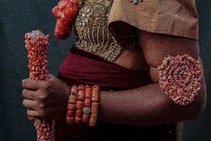 Photography Oil painting Close-up of coral beaded staff and bracelets of a Rivers bride against dark background.