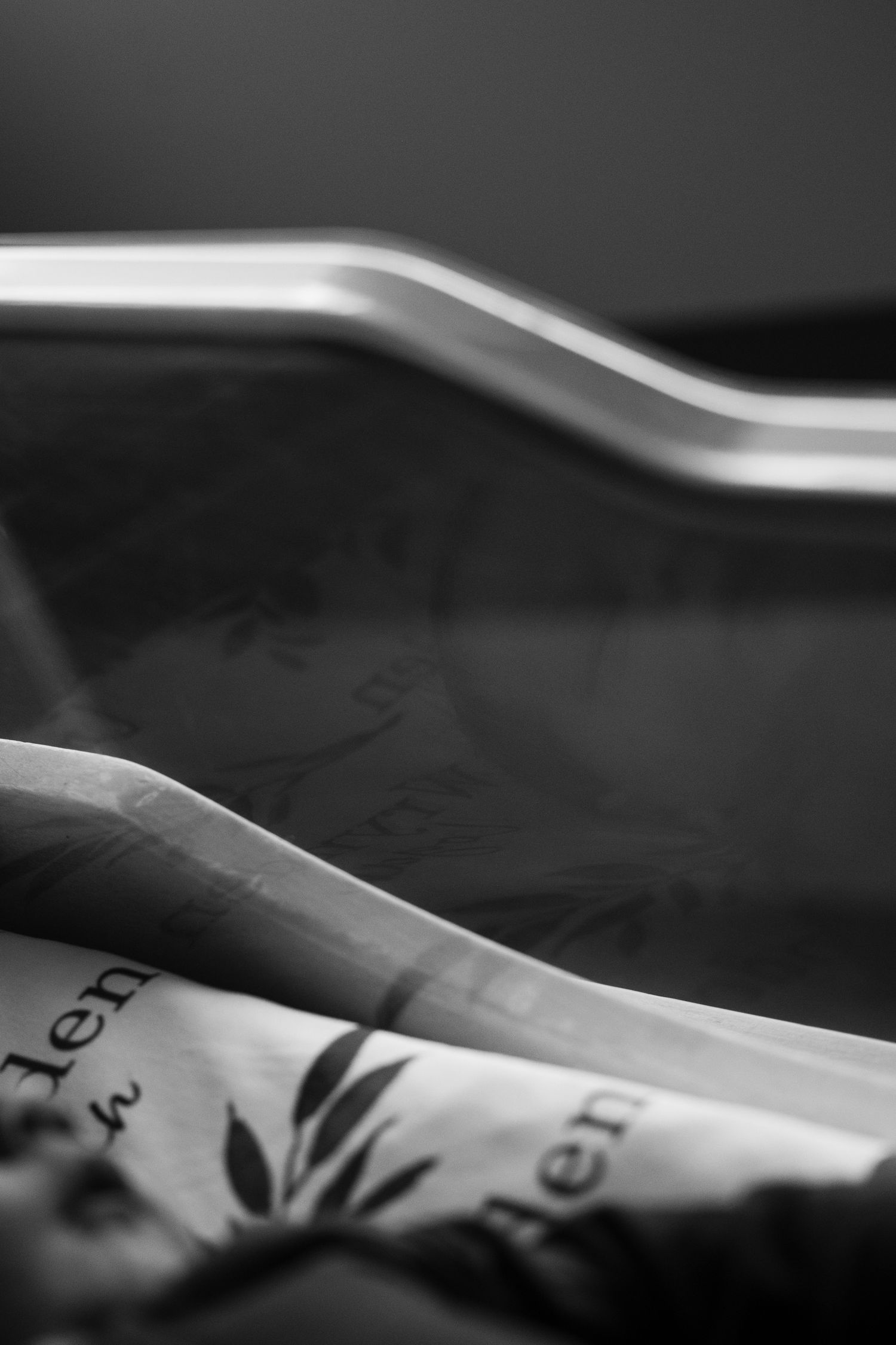 A black and white macro photograph showing curled pages of a book or document with soft shadows and curves.
