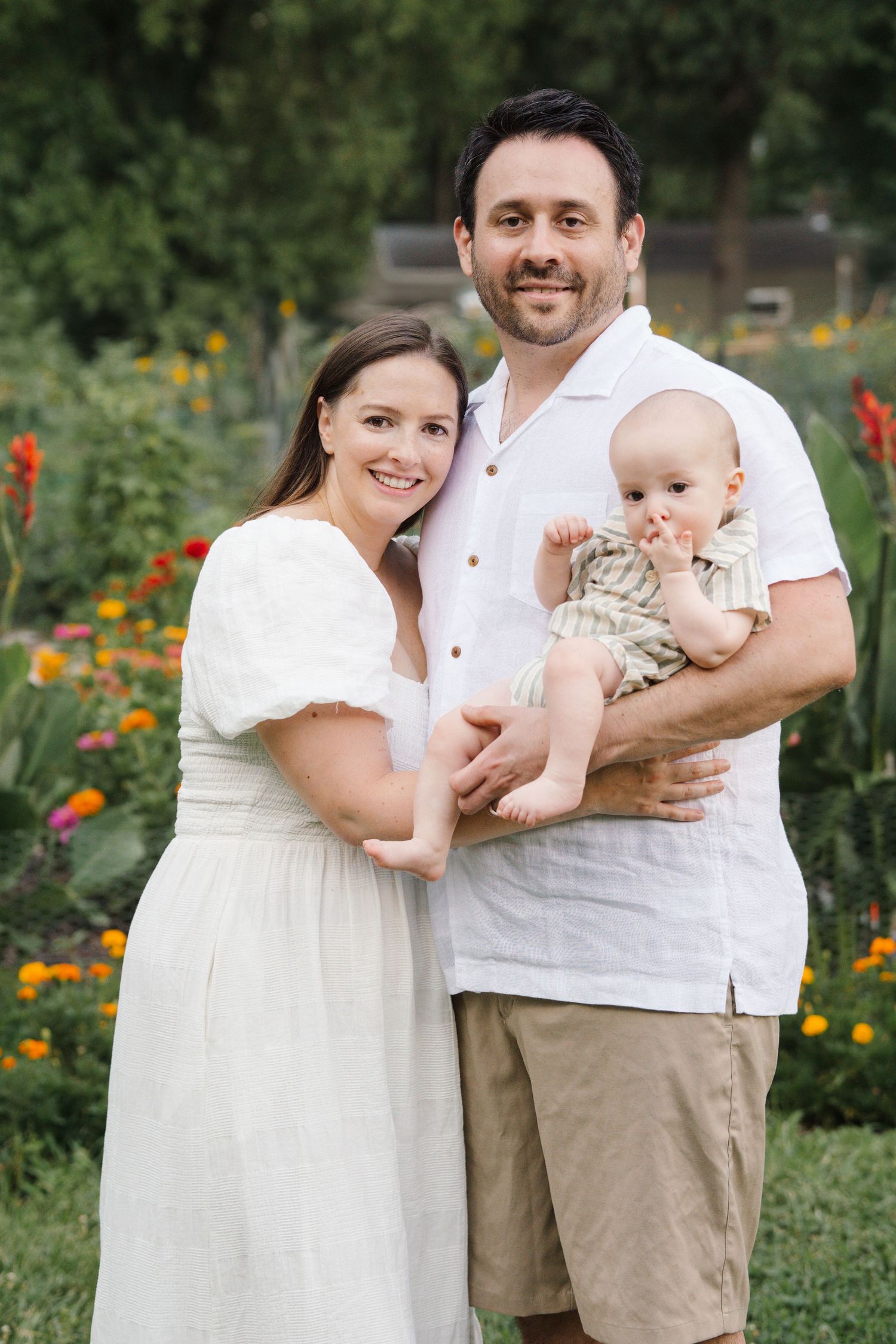 Family hugging together in community gardens at Barclay Farmstead, a picturesque backdrop for family portraits in Cherry Hill, NJ.