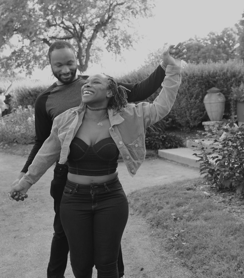 A joyful black and white photo capturing a celebratory moment in a garden setting.
