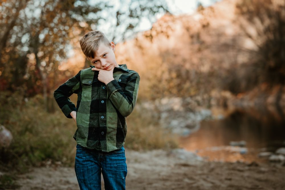 A playful outdoor family photoshoot with warm autumn lighting and natural scenery.