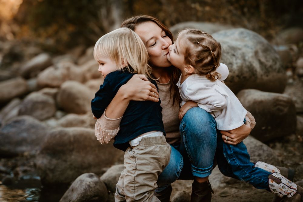 An intimate family portrait session among rocks and natural elements during sunset.