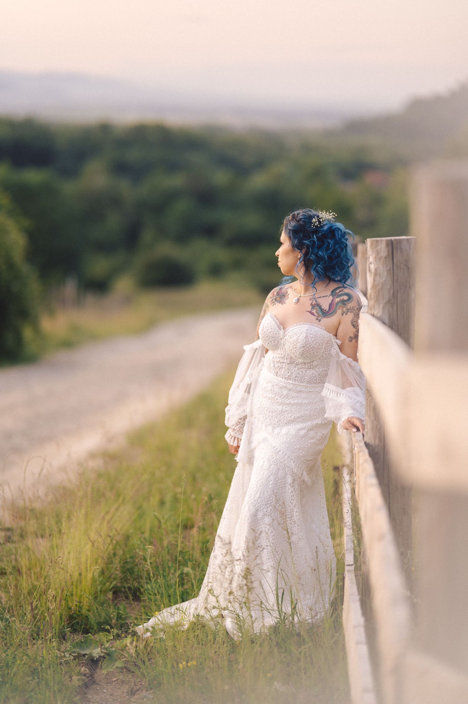 A dreamy sequence of images showing a figure in a white flowing dress and blue hair sitting against a rural fence at sunset.
