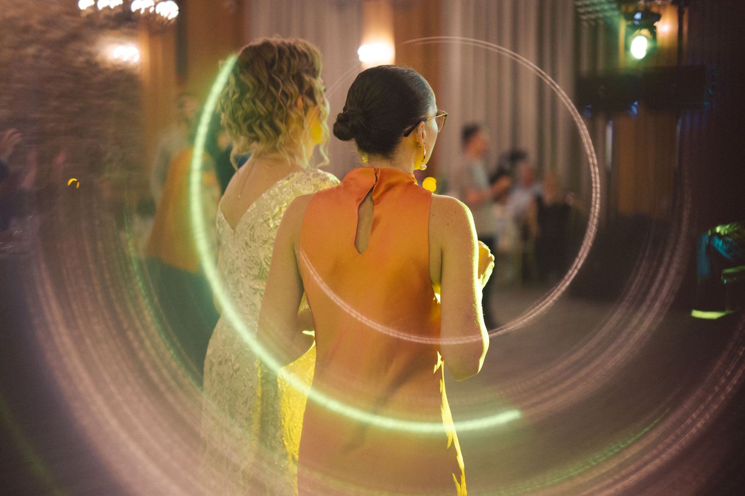 Abstract motion blur photography with warm glowing lights creating circular patterns in dark environment.
