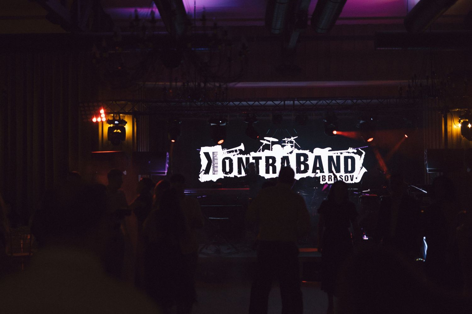 A series of dark nighttime performance venue exteriors with illuminated signage and purple lighting.