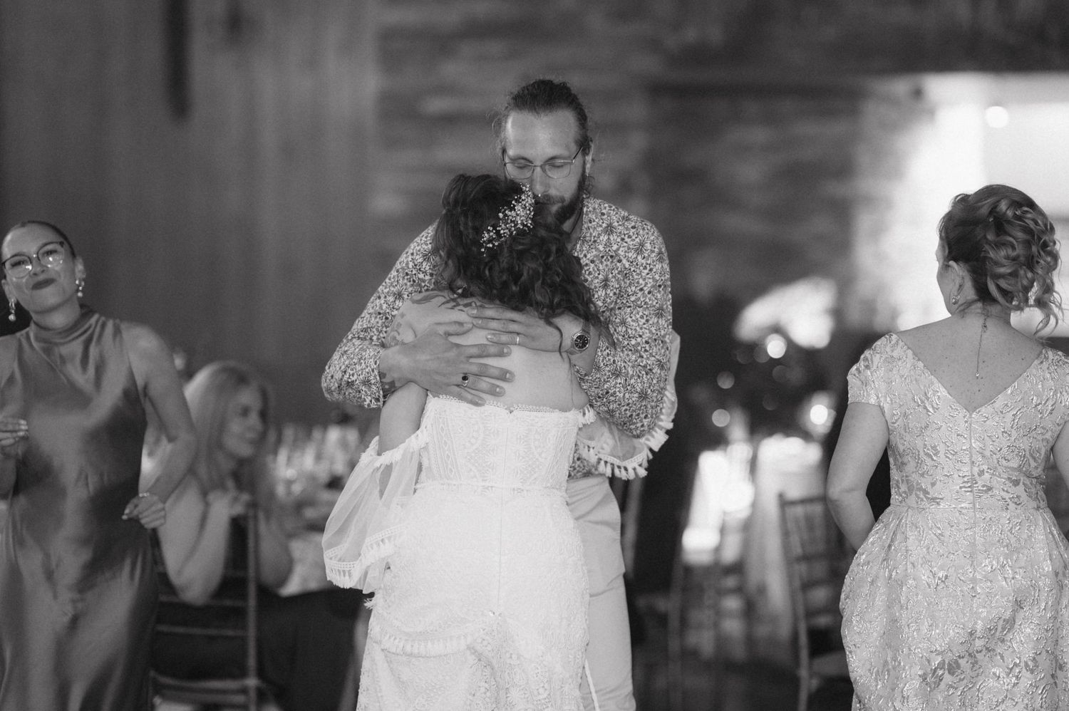 An intimate slow dance embrace at a wedding reception captured in black and white photography.