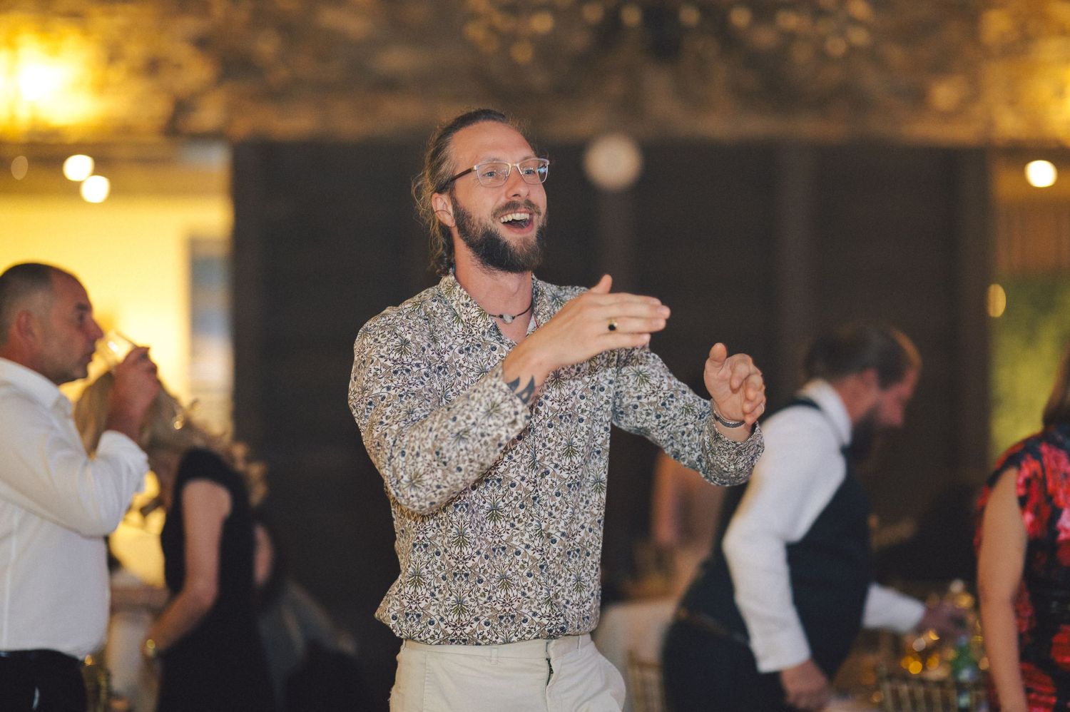 People dancing and celebrating at an evening wedding reception with warm lighting and festive atmosphere.