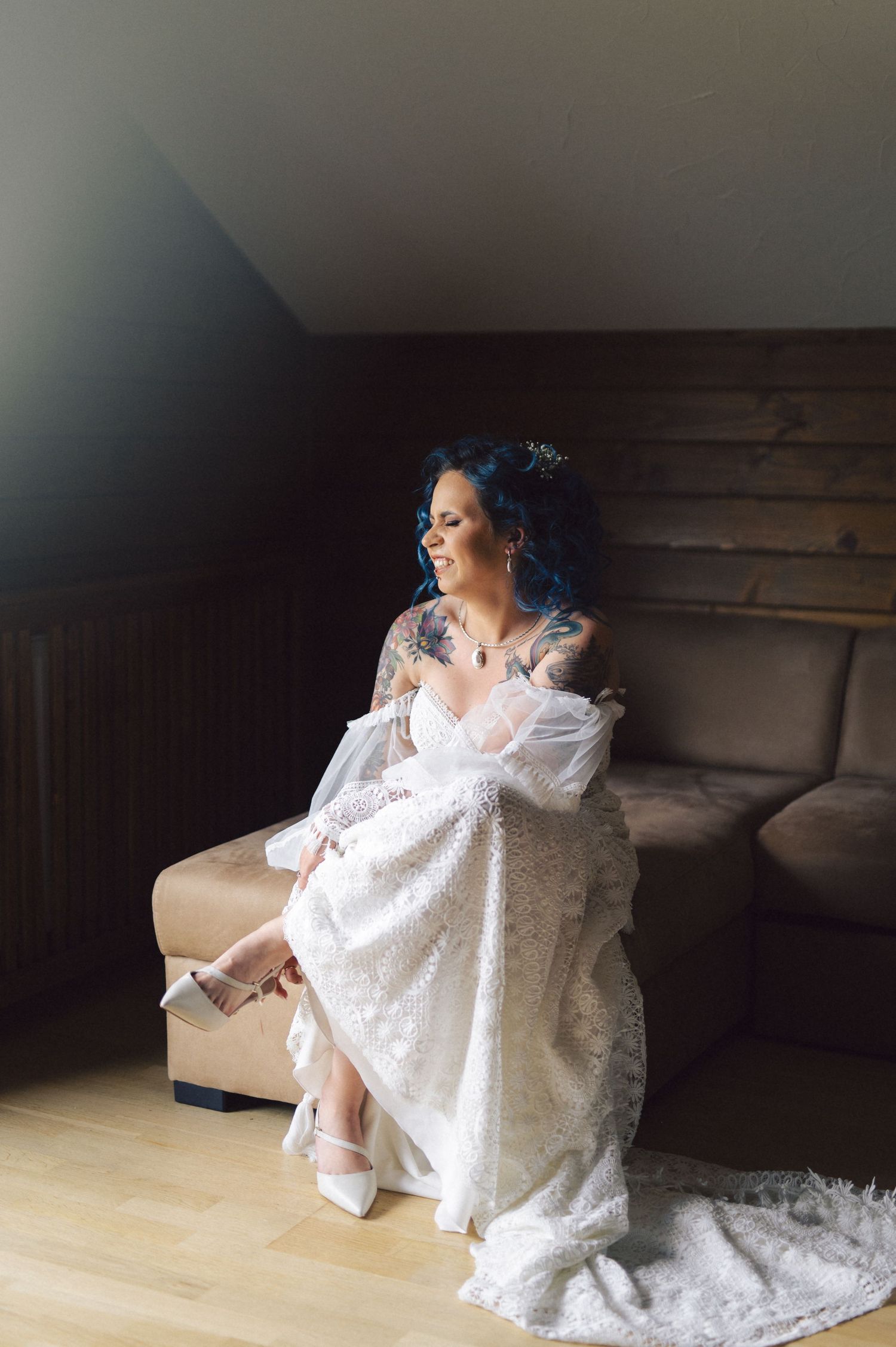 Person in a flowing white lace dress poses gracefully against a rustic wooden backdrop in a series of artistic portraits.