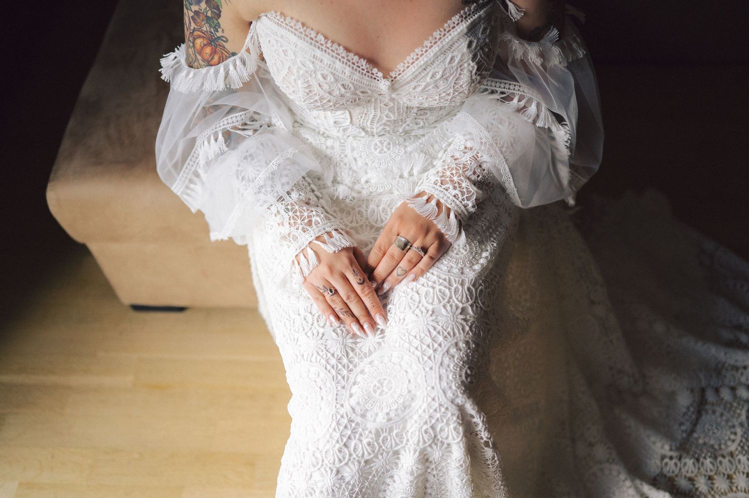 Elegant white lace wedding gown with off-shoulder puff sleeves photographed in soft natural lighting.